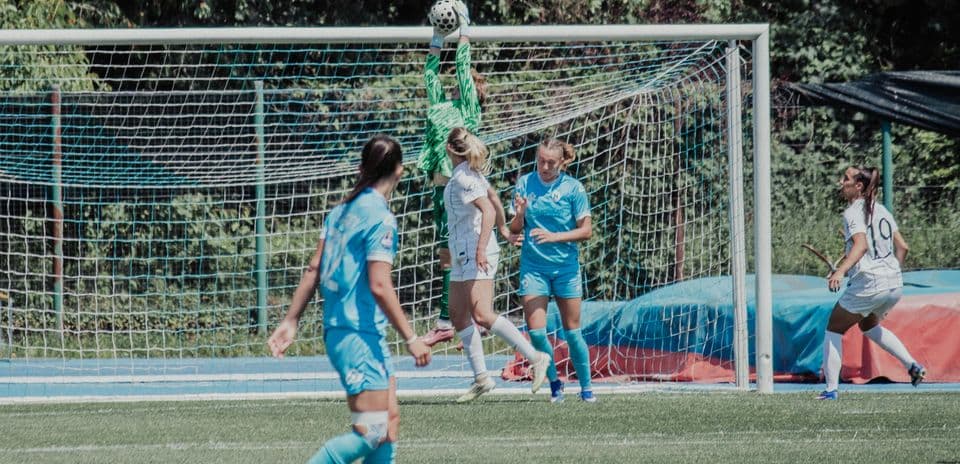 Portera atrapando el balón durante el partido