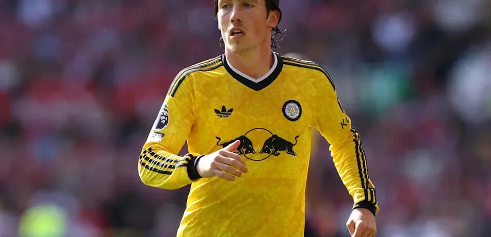 Jugador corriendo con camiseta amarilla durante partido