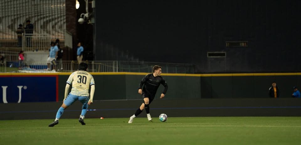 Jugador corriendo con el balón en el partido