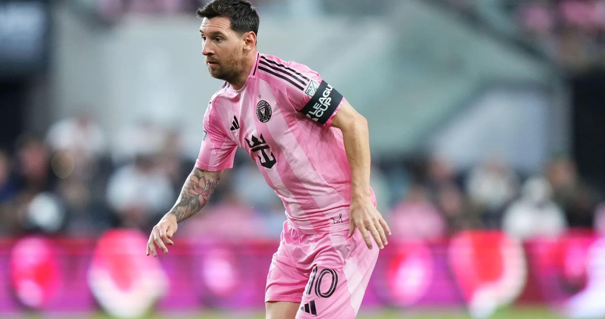 Lionel Messi corriendo en partido con camiseta rosa