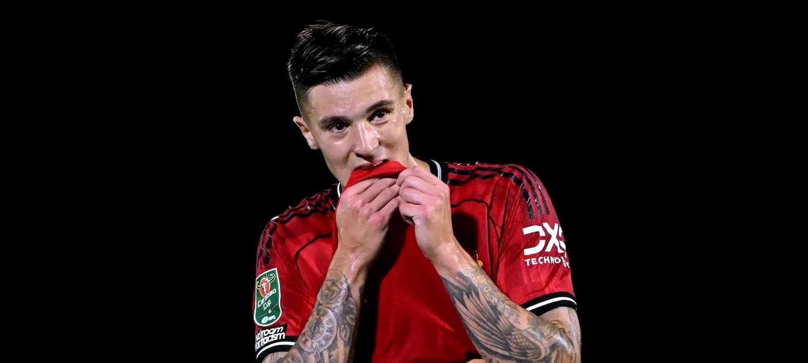 Jugador con camiseta roja sosteniendo su camiseta
