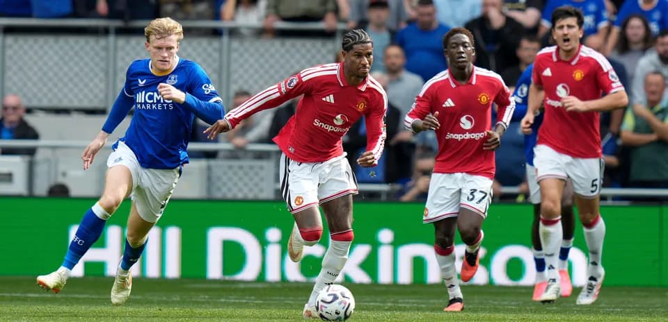 Jugadores de Manchester United corriendo tras el balón