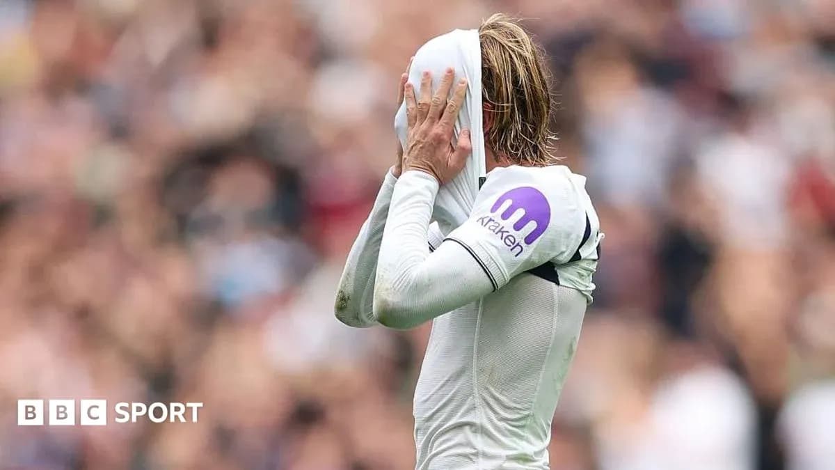 Jugador cubriendo su cara con la camiseta durante partido