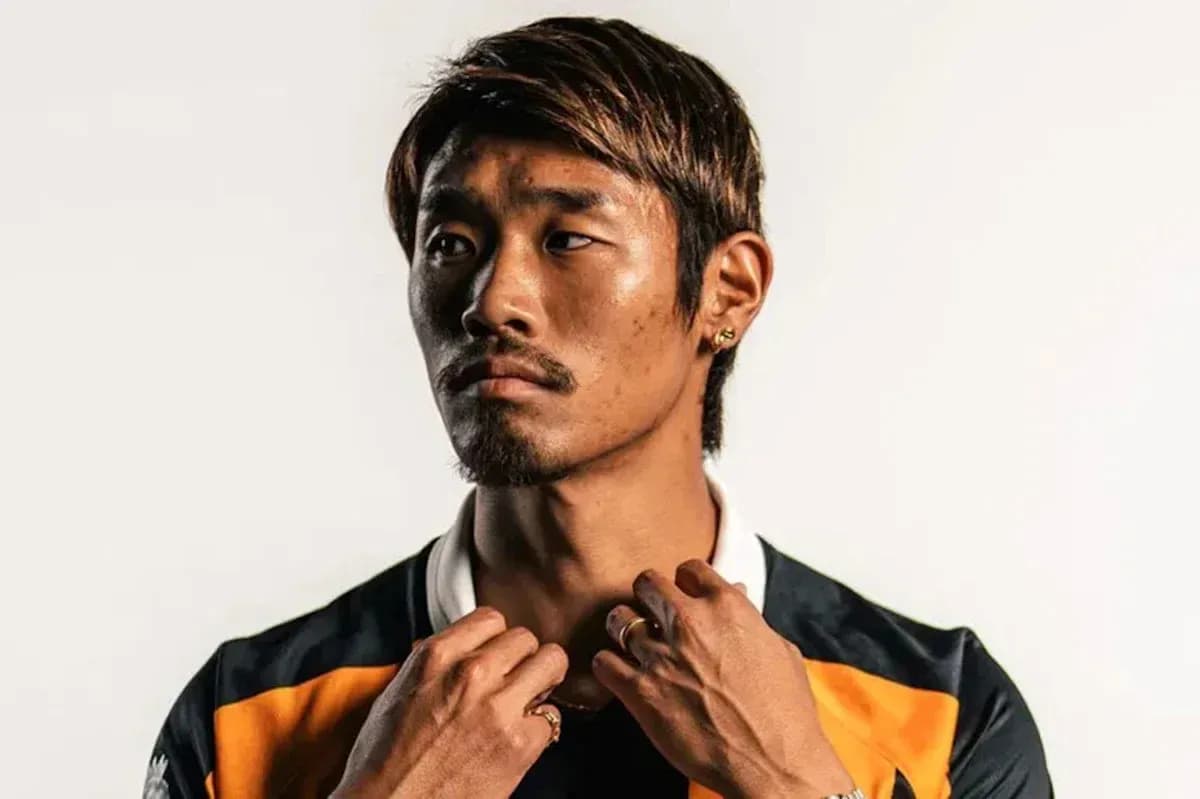 Jugador posando con camiseta deportiva en fondo neutro
