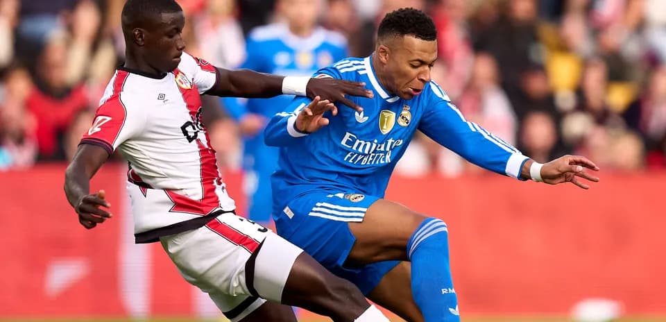 Jugador de Real Madrid siendo derribado por adversario