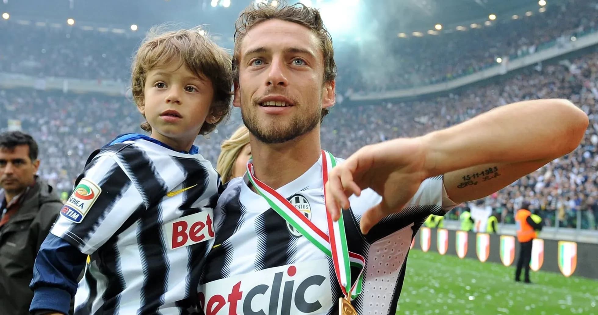Jugador de Juventus sosteniendo a un niño en el campo