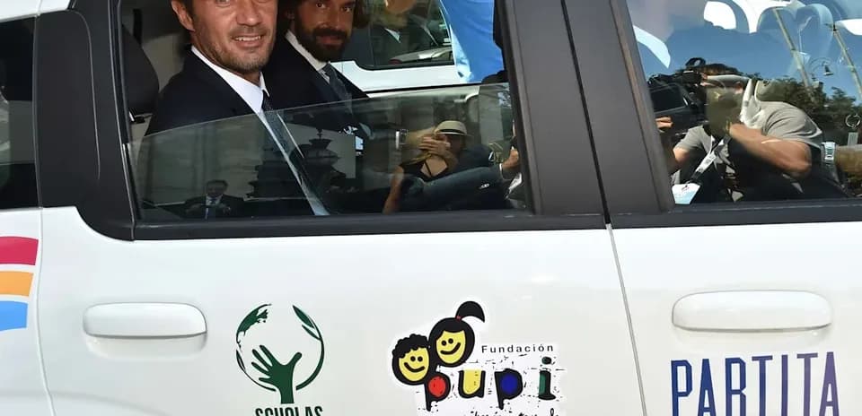 Dos hombres sentados en un coche con logotipos