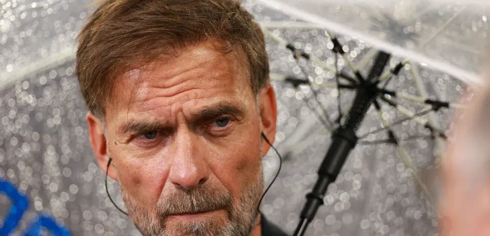 Entrenador bajo la lluvia con paraguas transparente