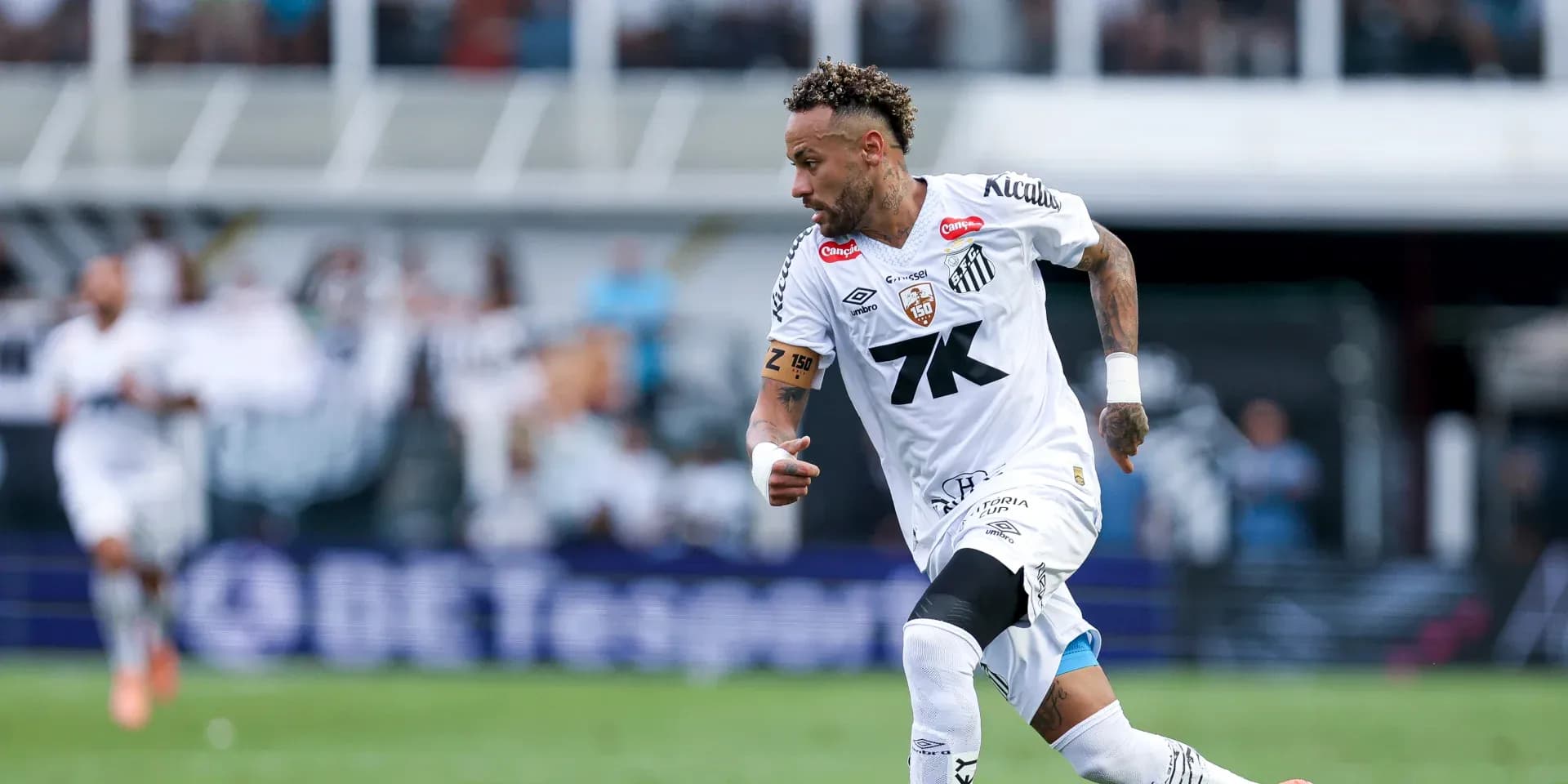 Jugador de Santos corriendo con el balón en el campo