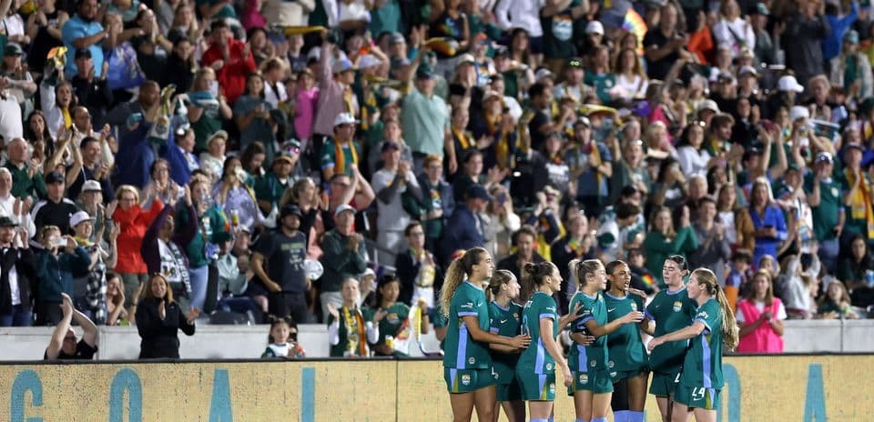 Jugadoras celebrando un gol con aficionados