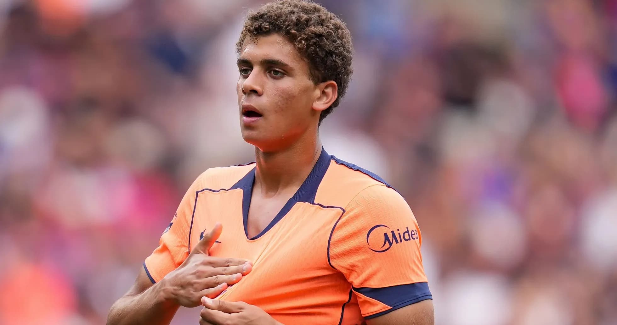 Jugador con camiseta naranja en el campo