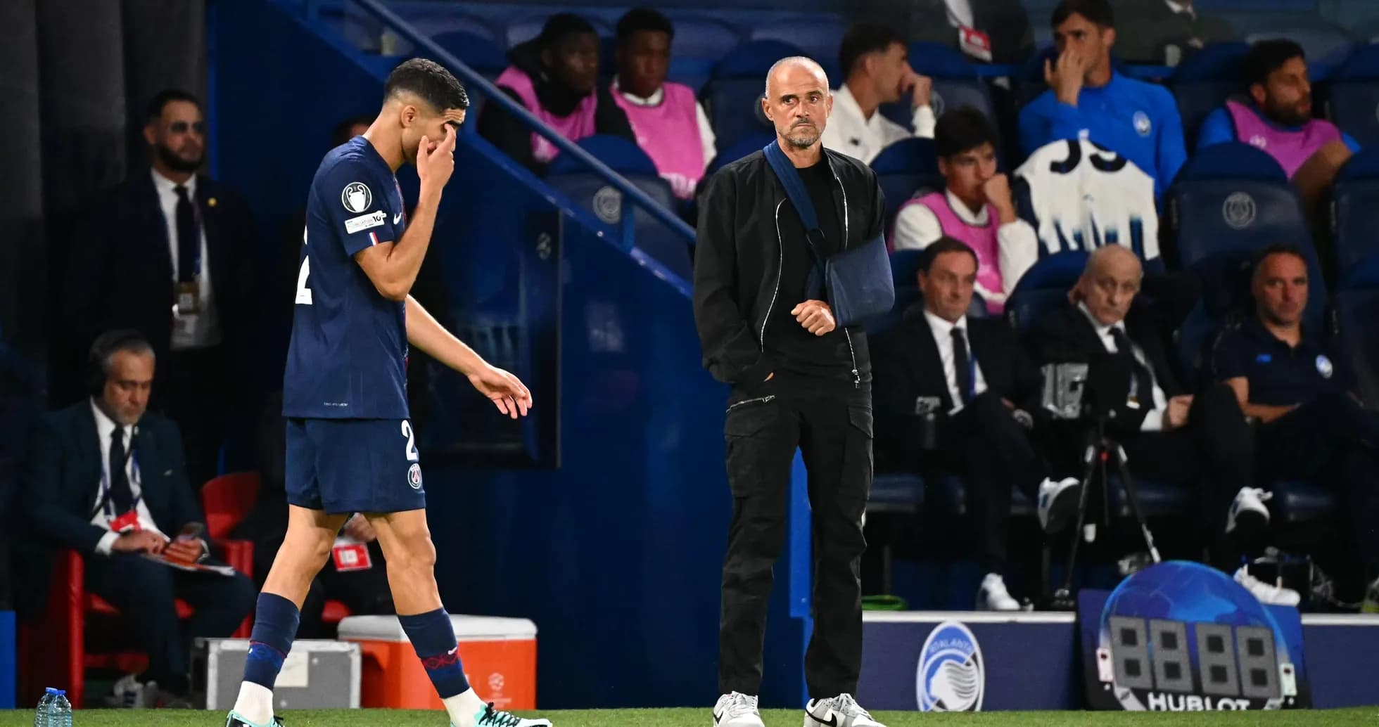 Jugador saliendo del campo y entrenador observando