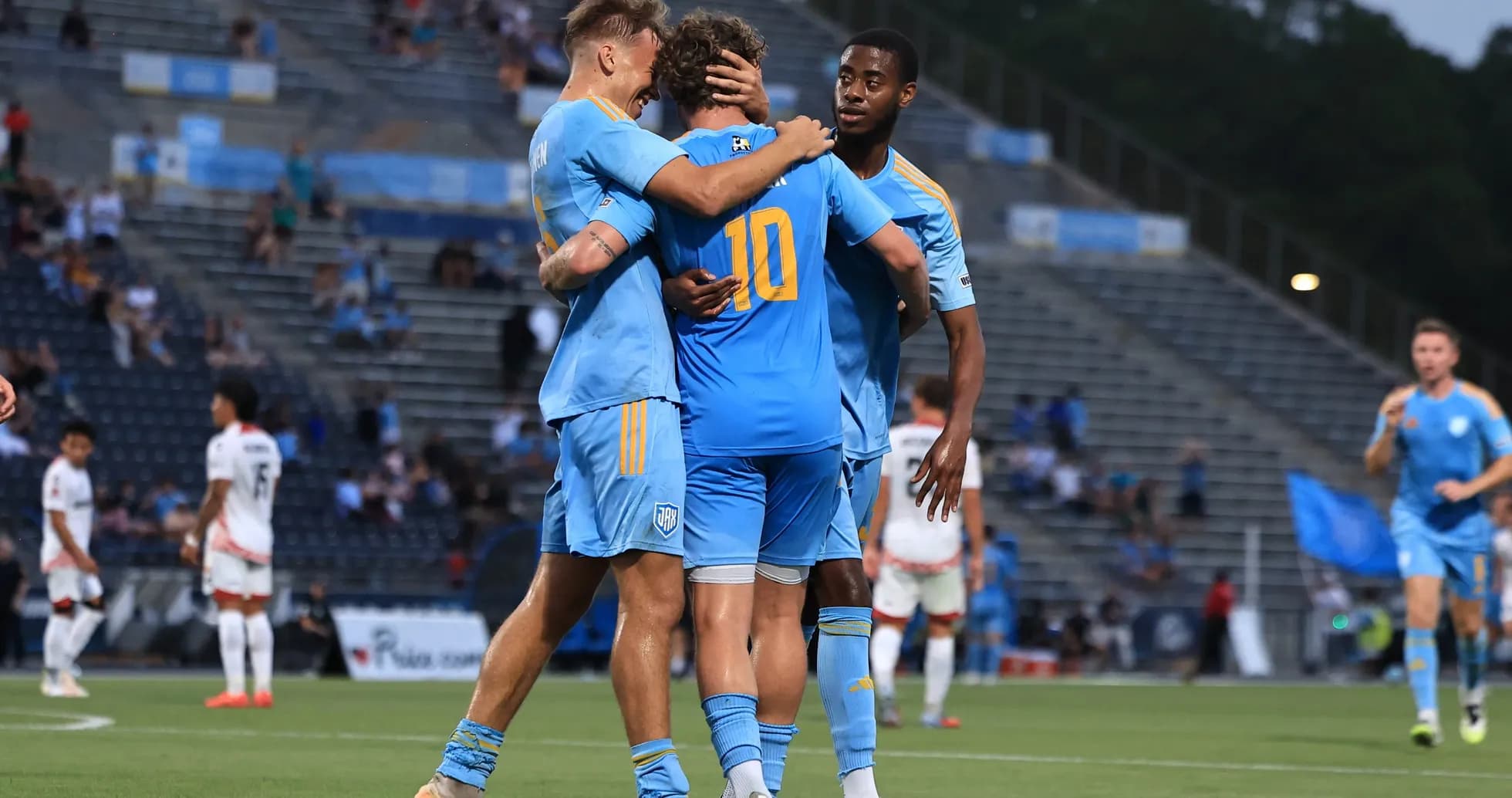 Jugadores celebrando un gol en partido de fútbol