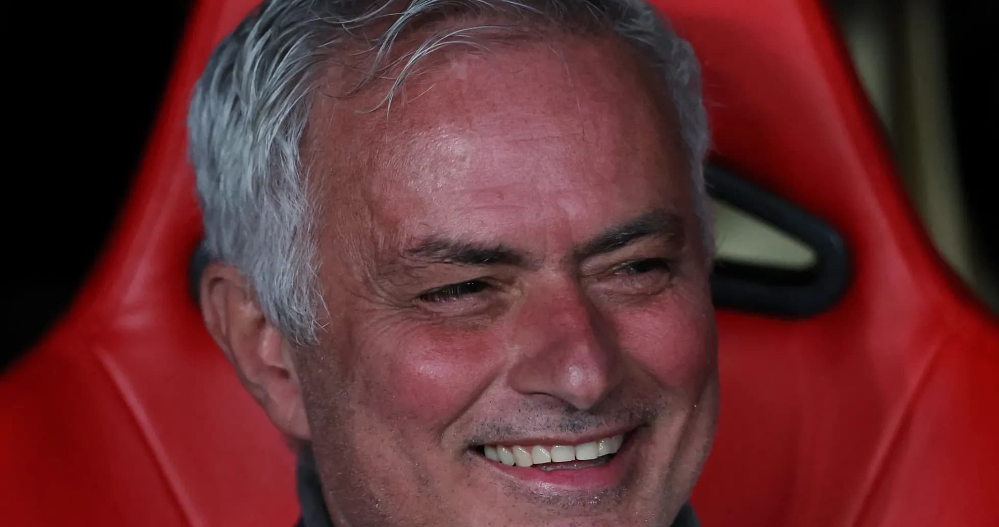 Entrenador sentado en el banquillo sonriendo