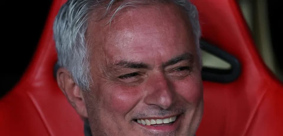 Entrenador sentado en el banquillo sonriendo