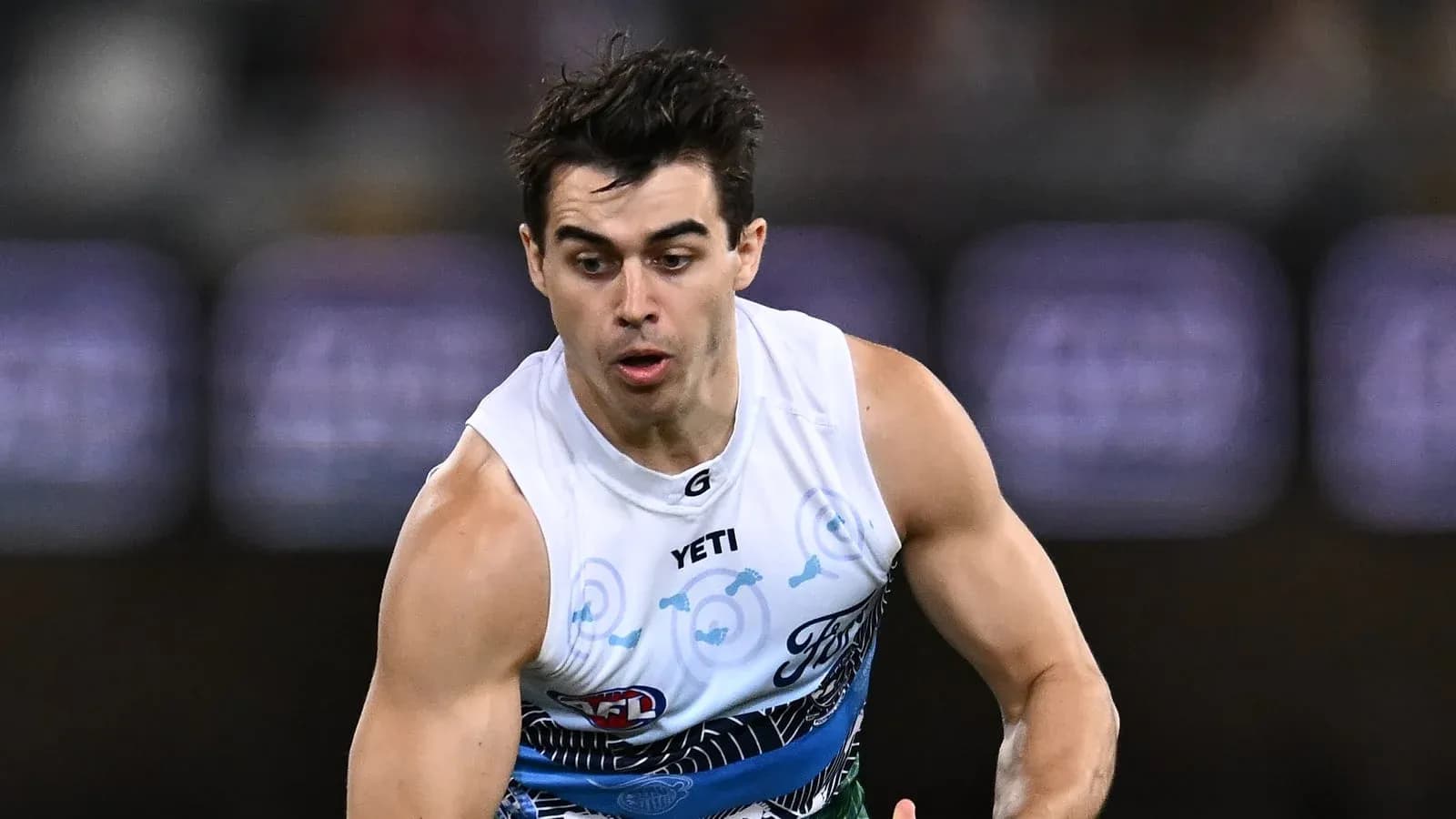 Jugador corriendo con balón en partido de AFL