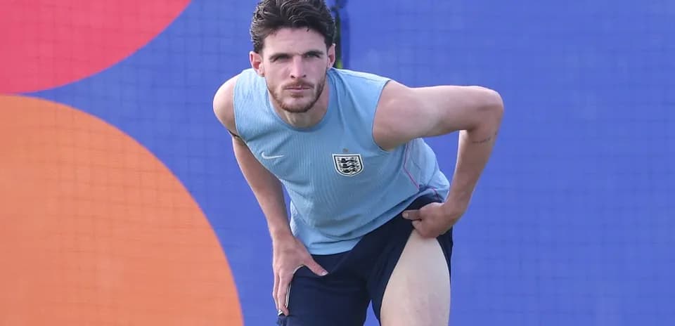 Jugador estirándose durante entrenamiento en campo