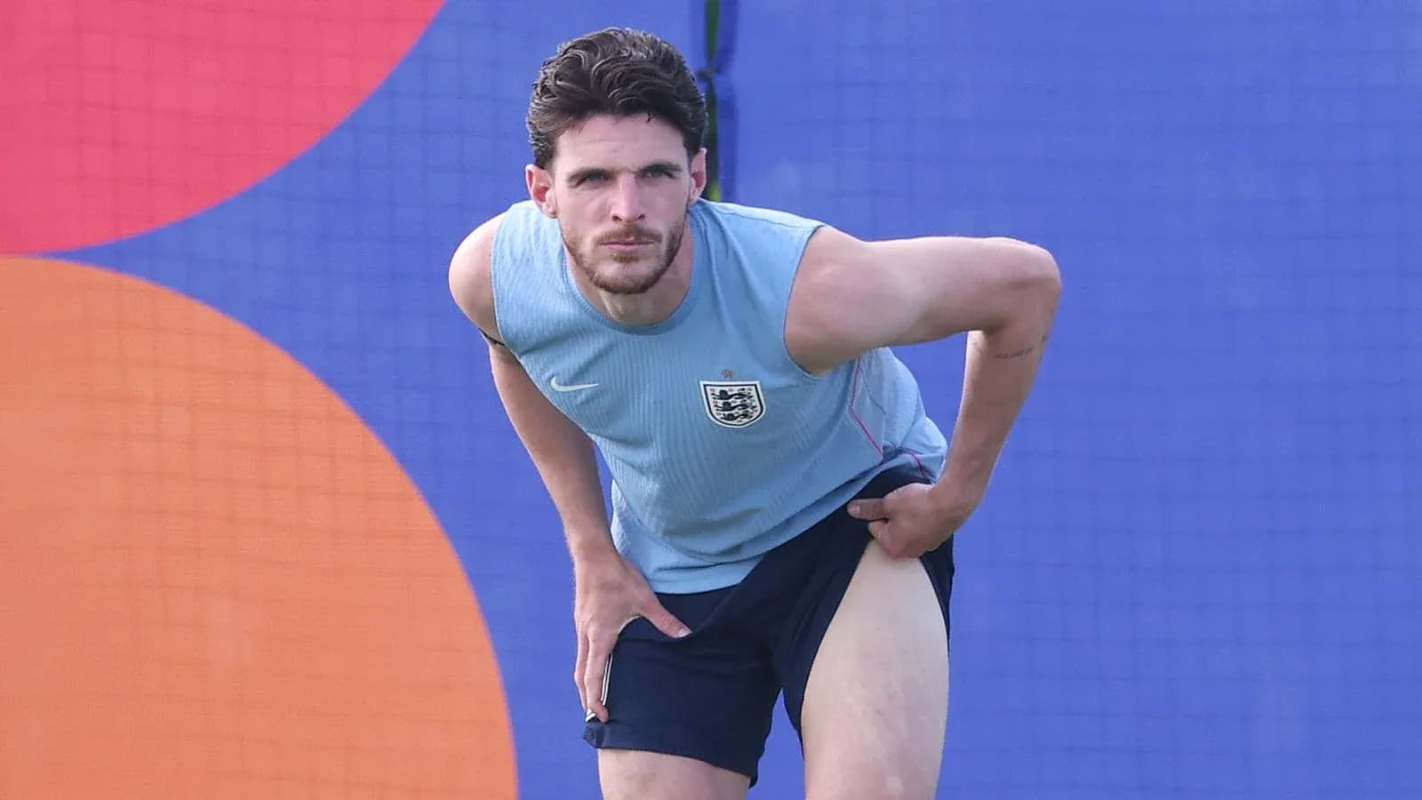 Jugador estirándose durante entrenamiento en campo