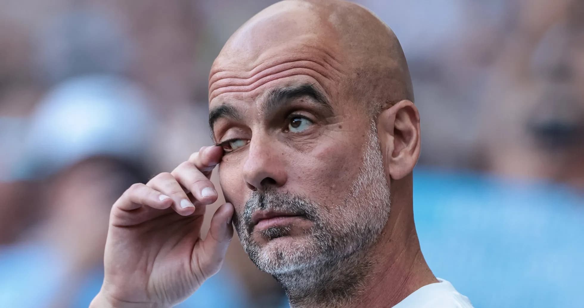 Entrenador ajustándose el ojo en el banquillo