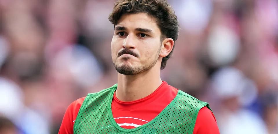 Jugador en la banca con chaleco de entrenamiento verde