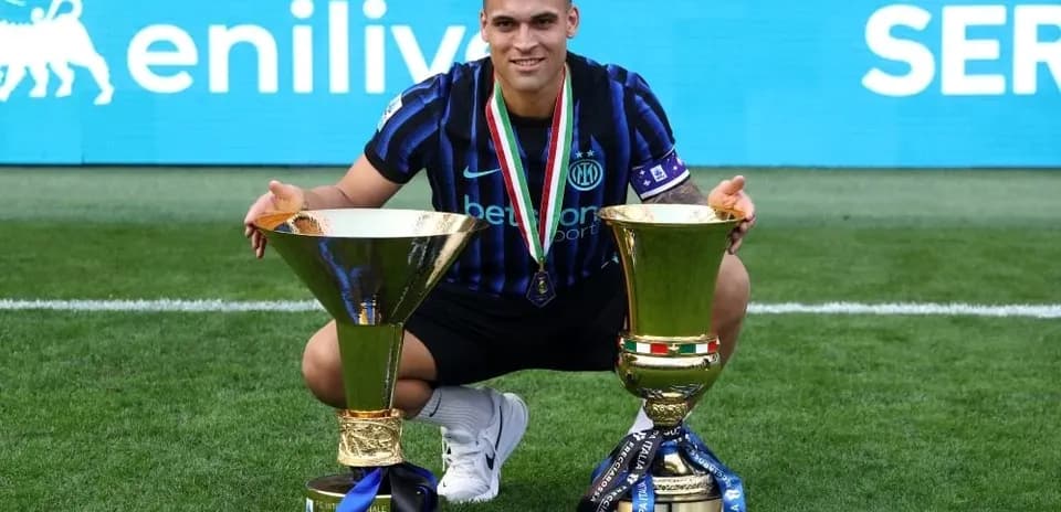 Jugador de Inter celebrando con dos trofeos