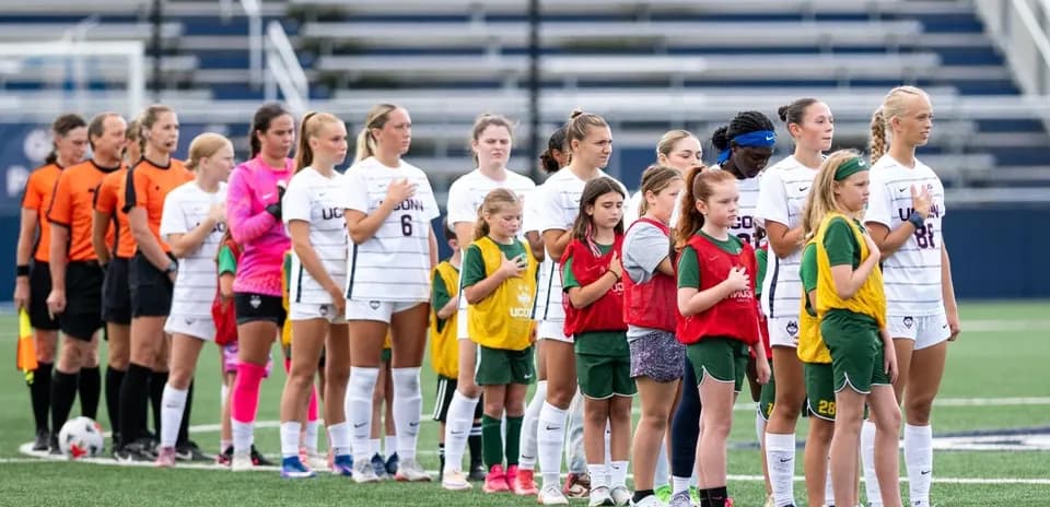 Jugadoras de UConn y árbitros alineados para el himno