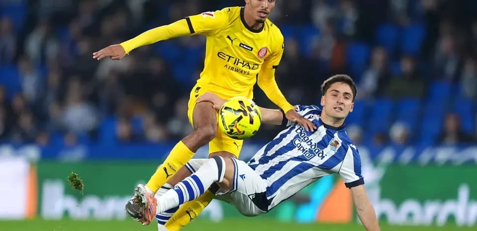 Jugador de Girona desafiando a un rival de Real Sociedad