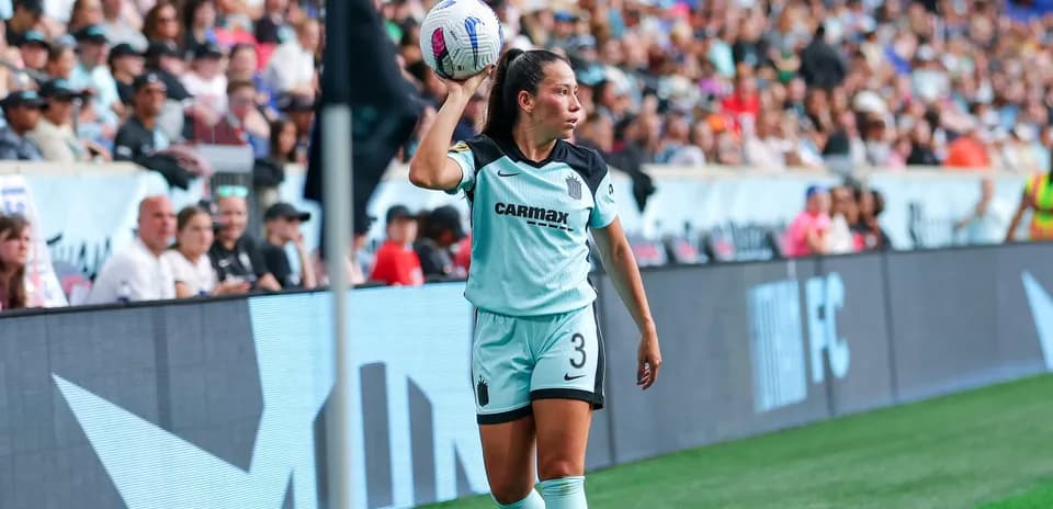 Jugadora lanzando el balón desde la banda