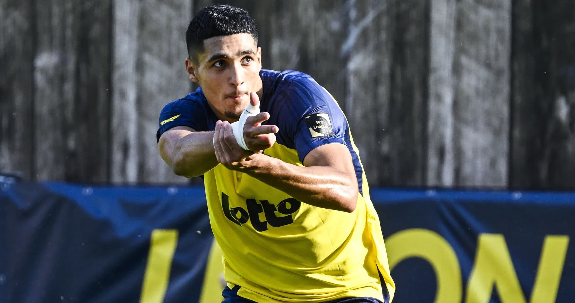 Jugador entrenando con camiseta amarilla y azul