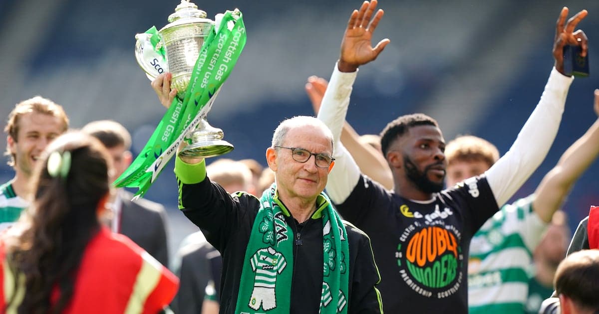 Hombre levantando trofeo con bufanda verde en celebración