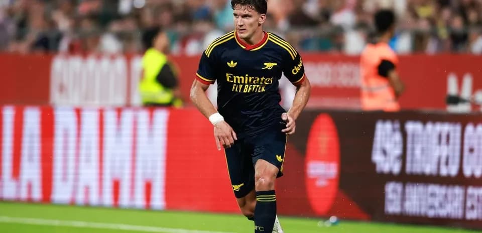 Jugador de Arsenal corriendo con el balón en el campo