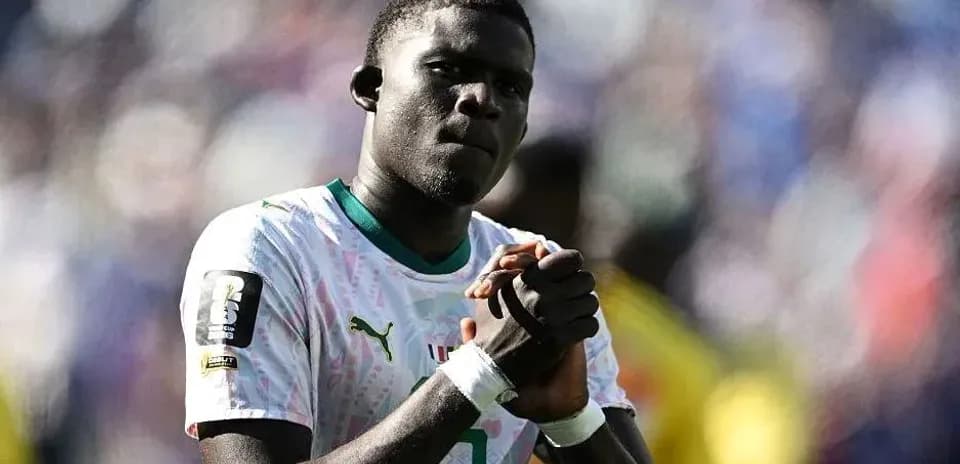 Jugador de fútbol con camiseta de Senegal en el campo