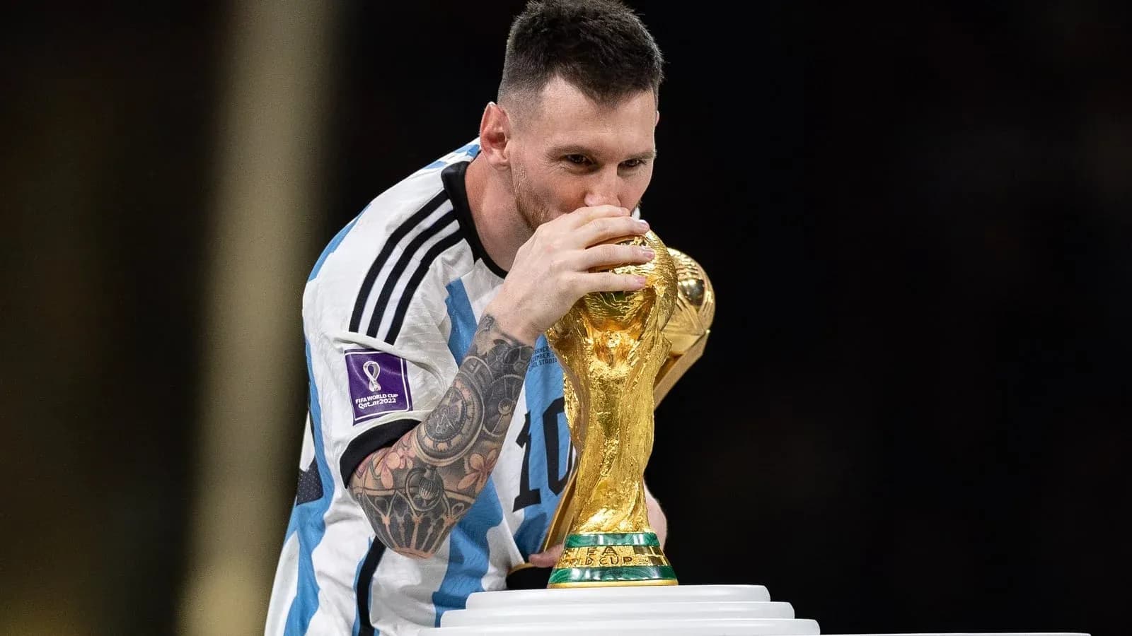 Jugador sosteniendo la Copa del Mundo en el podio