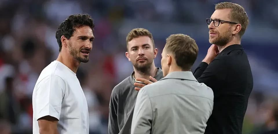 Cuatro hombres conversando en evento deportivo