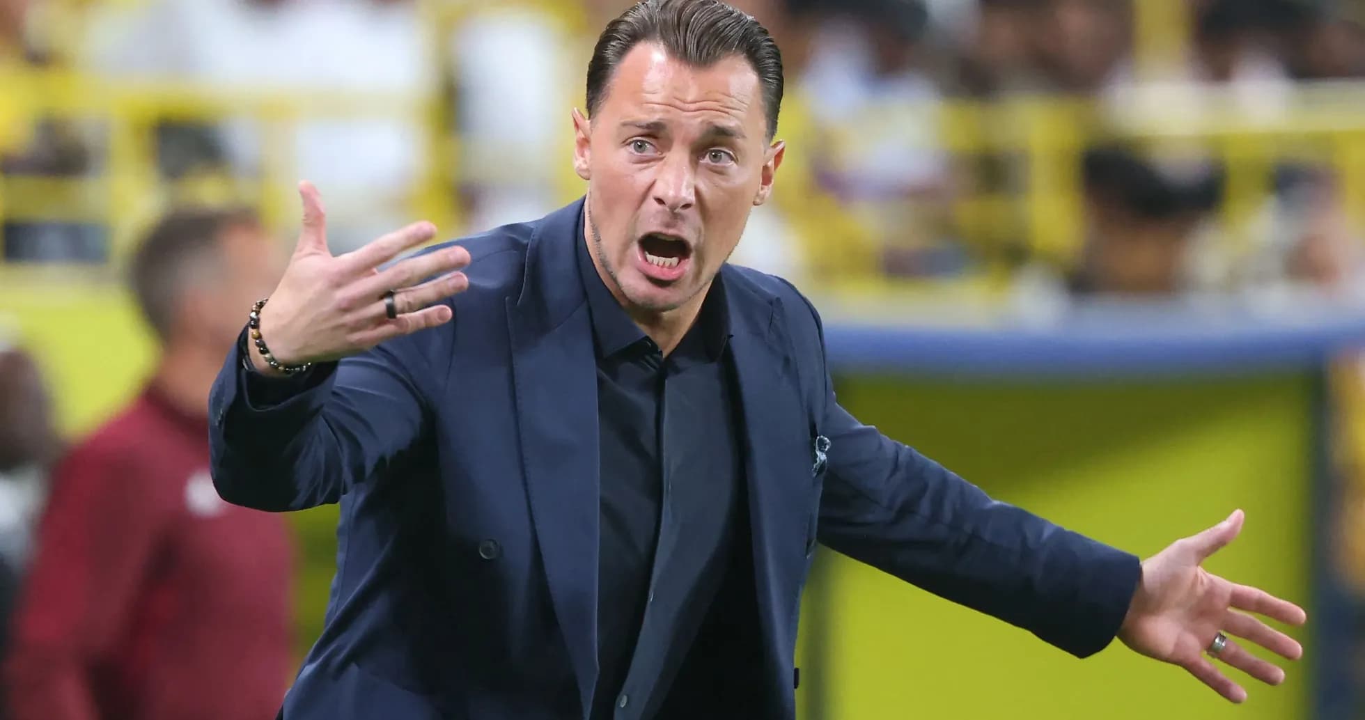Entrenador gesticulando durante un partido de fútbol