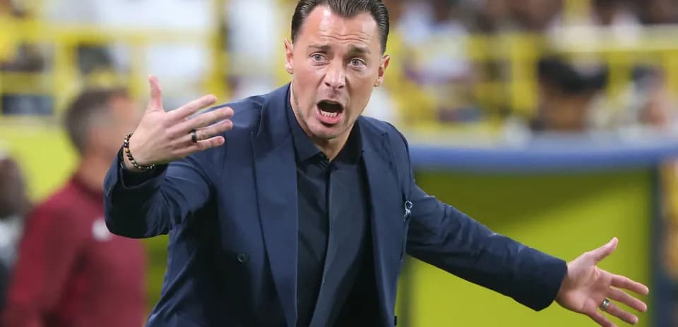 Entrenador gesticulando durante un partido de fútbol