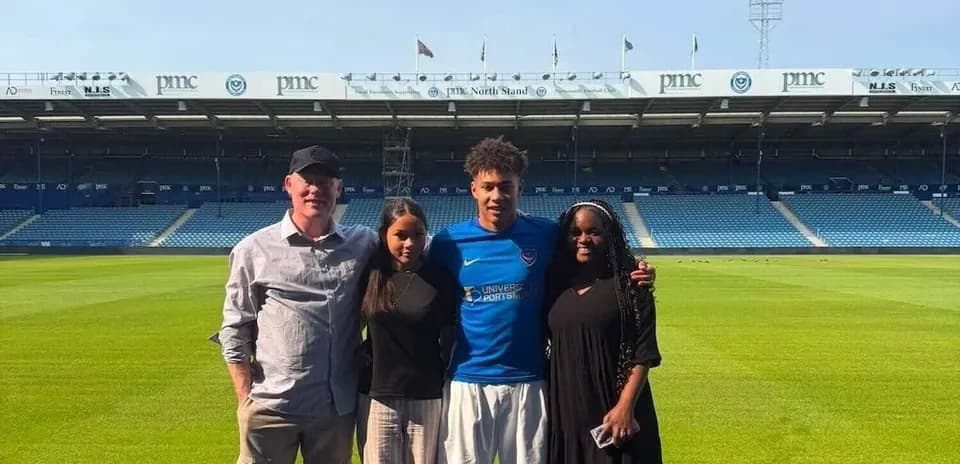 Cuatro personas posando en el campo de fútbol
