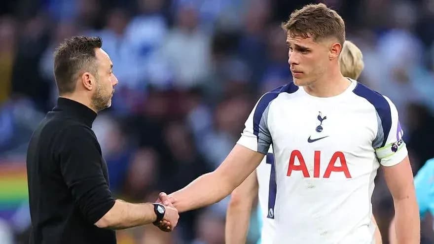 Entrenador y jugador de Tottenham estrechando manos