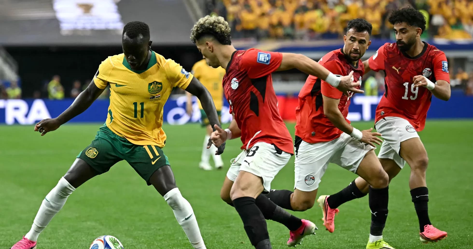 Jugador australiano driblando mientras es marcado por egipcios