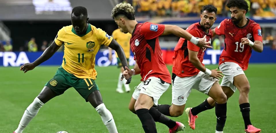 Jugador australiano driblando mientras es marcado por egipcios