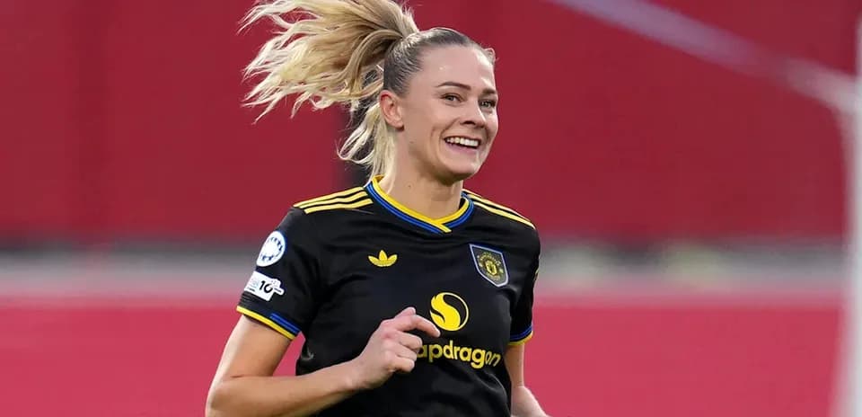 Jugadora sonriente corriendo en el campo de fútbol