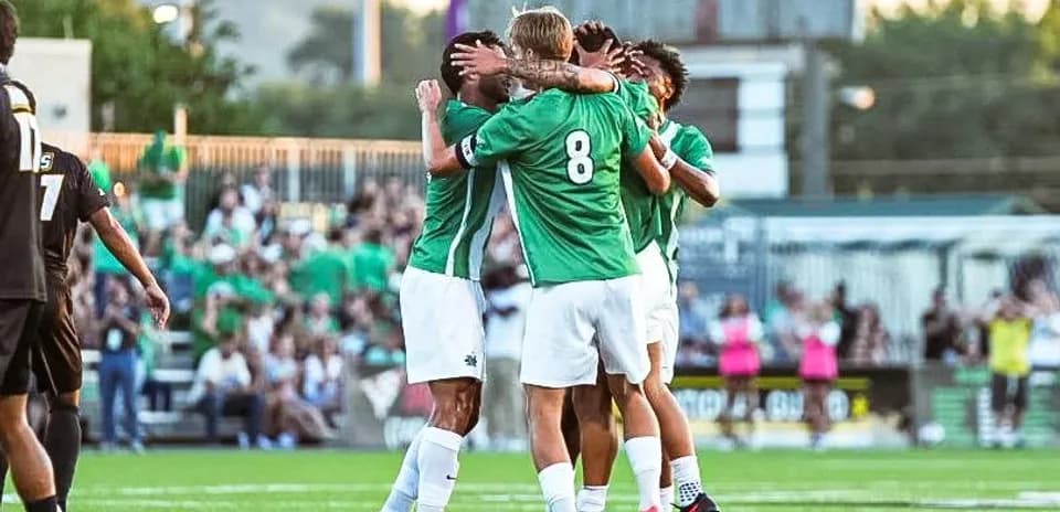 Jugadores celebrando un gol en el campo de fútbol