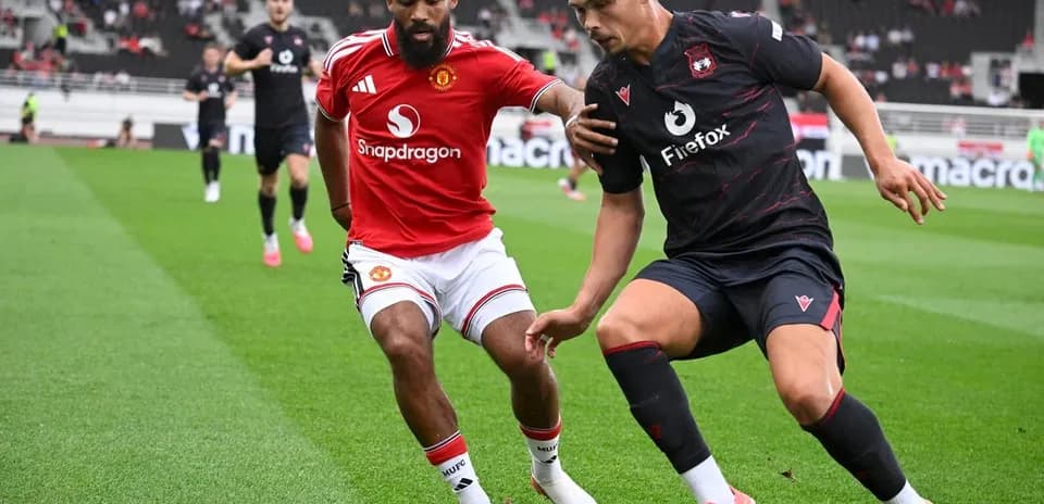 Dos jugadores compitiendo por el balón en el campo