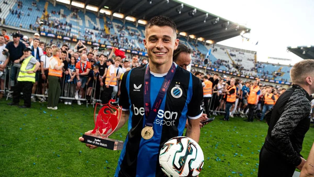 Jugador sosteniendo trofeo y balón en celebración