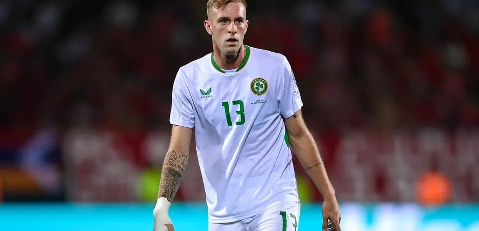 Jugador de fútbol en uniforme de Irlanda en el campo