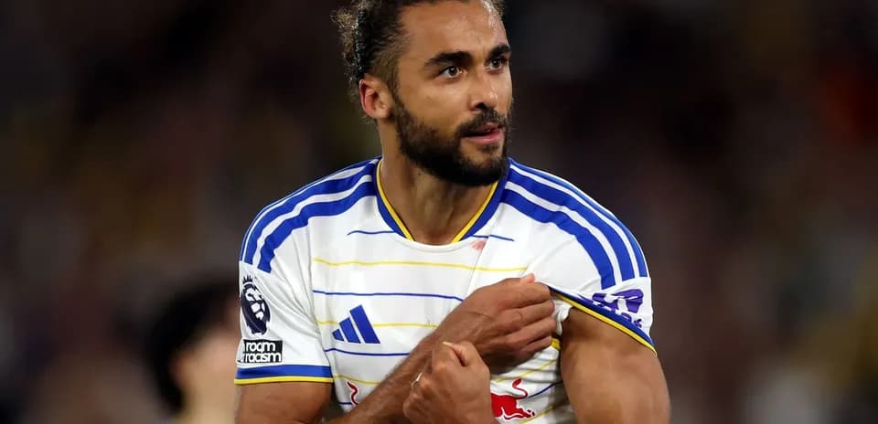 Jugador mostrando el escudo del equipo durante partido