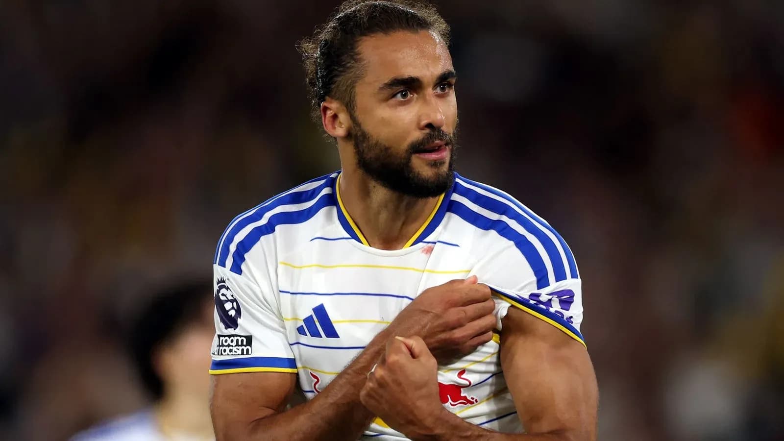 Jugador mostrando el escudo del equipo durante partido