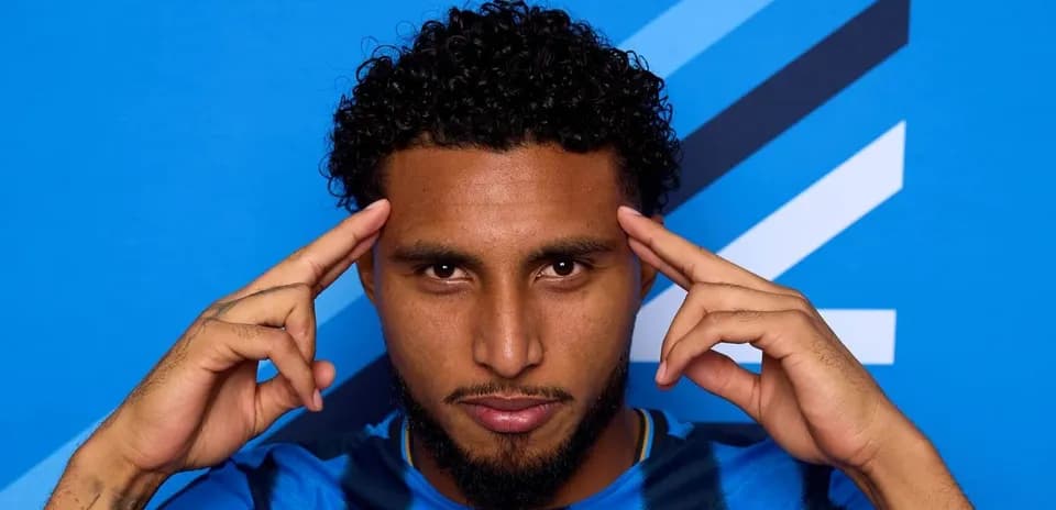 Jugador posando con fondo azul y camiseta azul