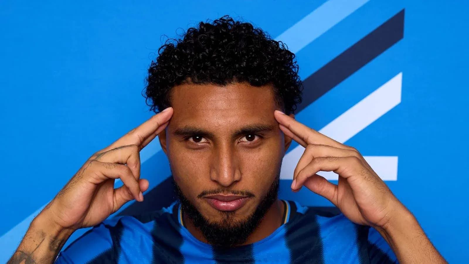 Jugador posando con fondo azul y camiseta azul