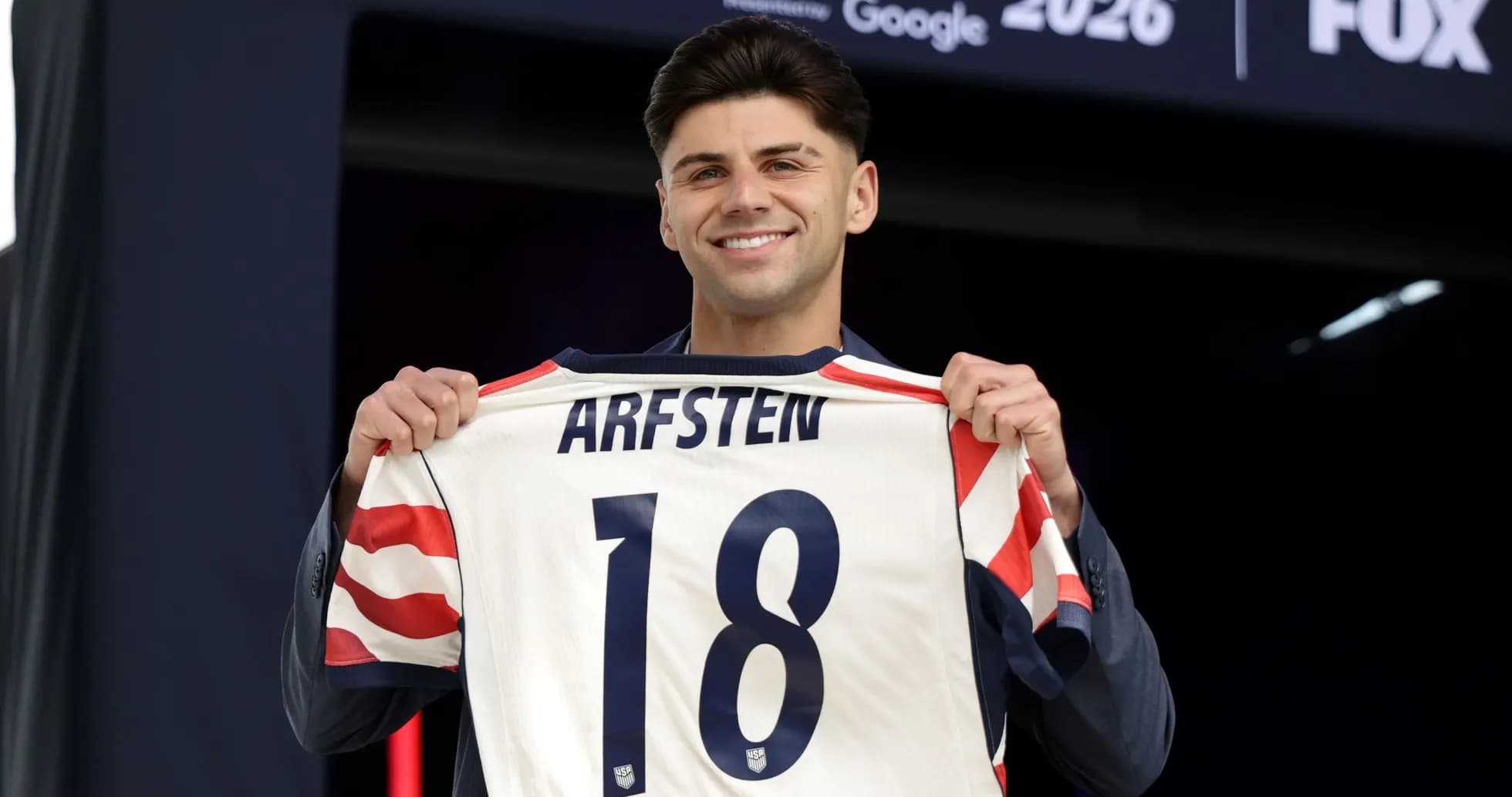Jugador sostiene camiseta con el nombre ARFSTEN